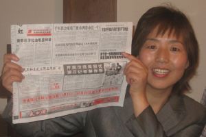 Li Suying shows newspaper article.